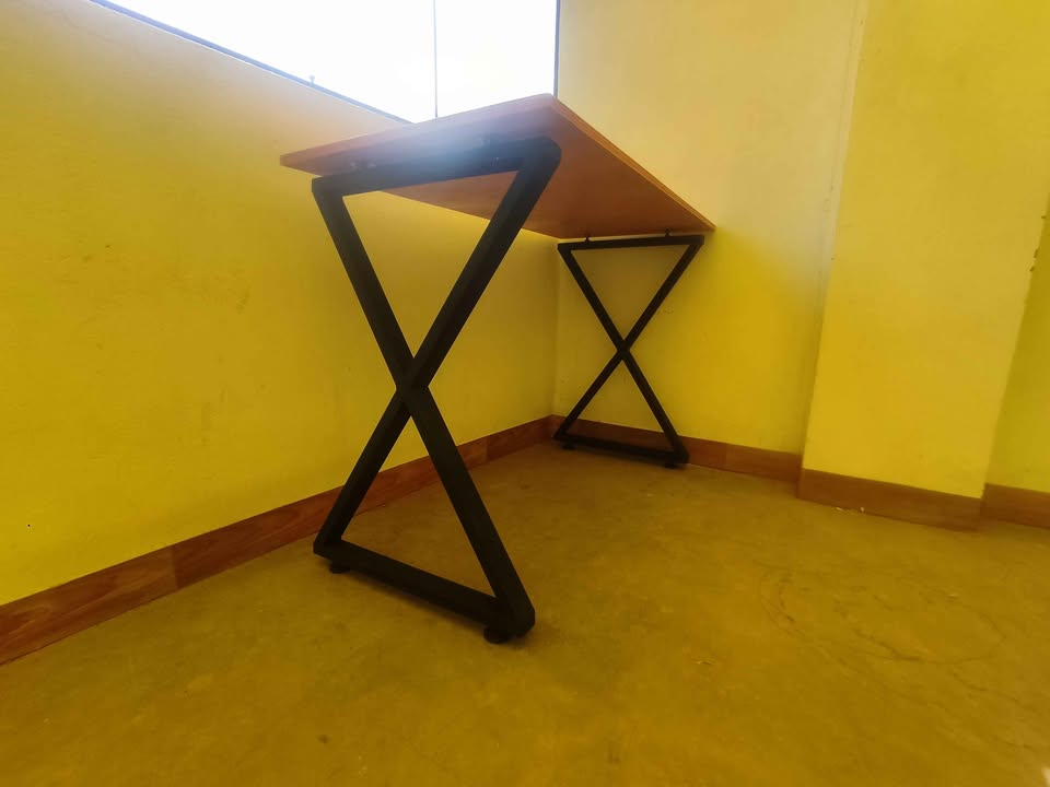 Vista inferior de las patas cruzadas de acero negro del escritorio industrial